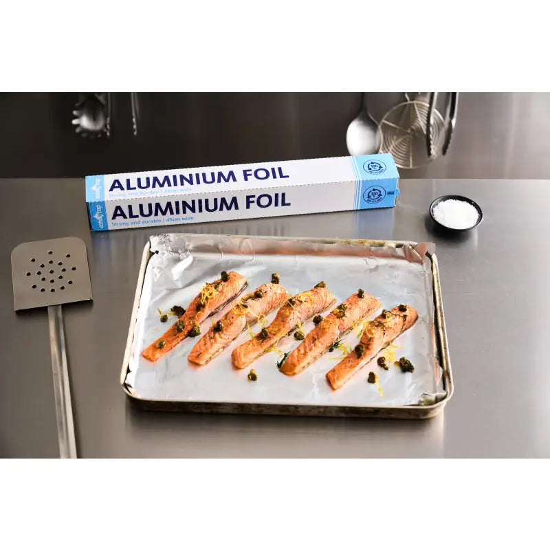 Salmon fillets with capers and lemon zest on foil cutter-lined baking sheet