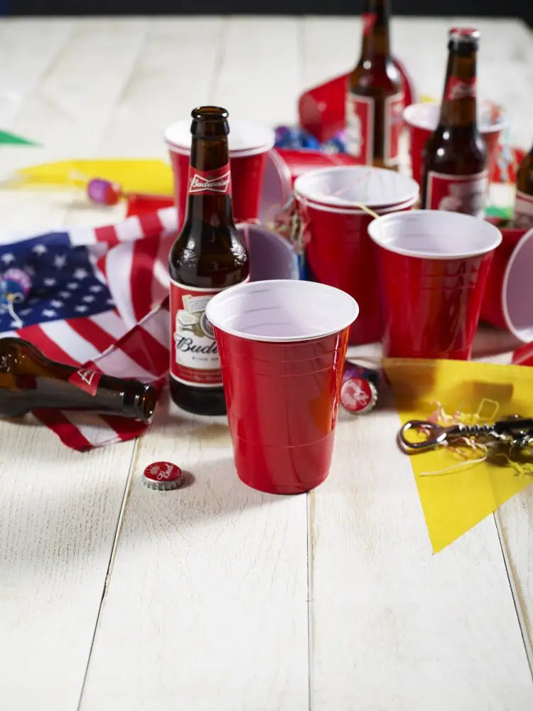 Red plastic 12oz red party cups with white interior and ridged sides ideal for casual gatherings and events