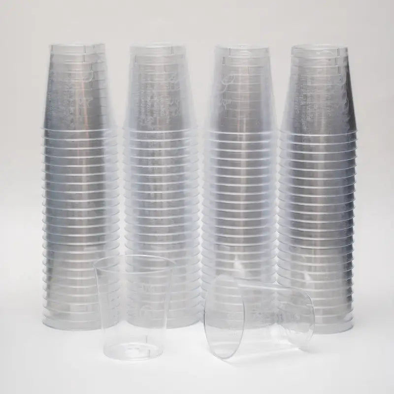 Stacks of clear 2cl plastic shot glasses with lining for precise measuring