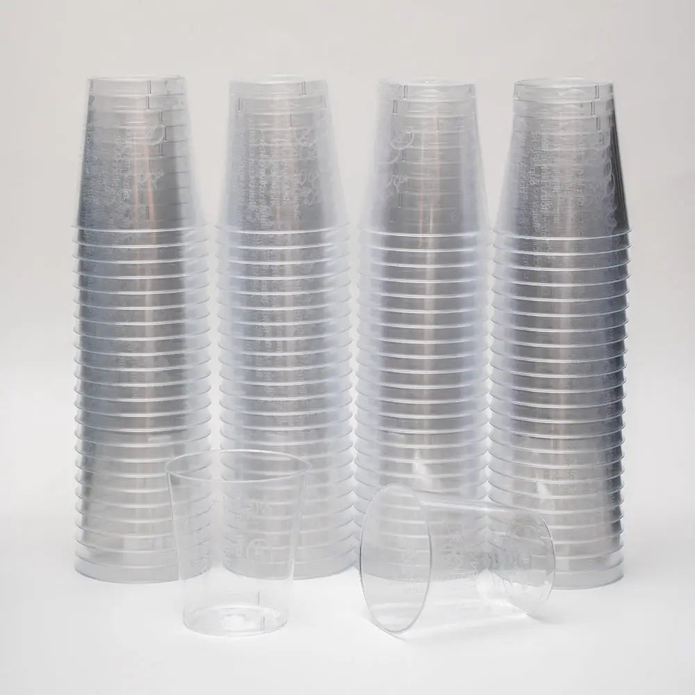 Stacks of clear 2cl plastic shot glasses with lining for precise measuring