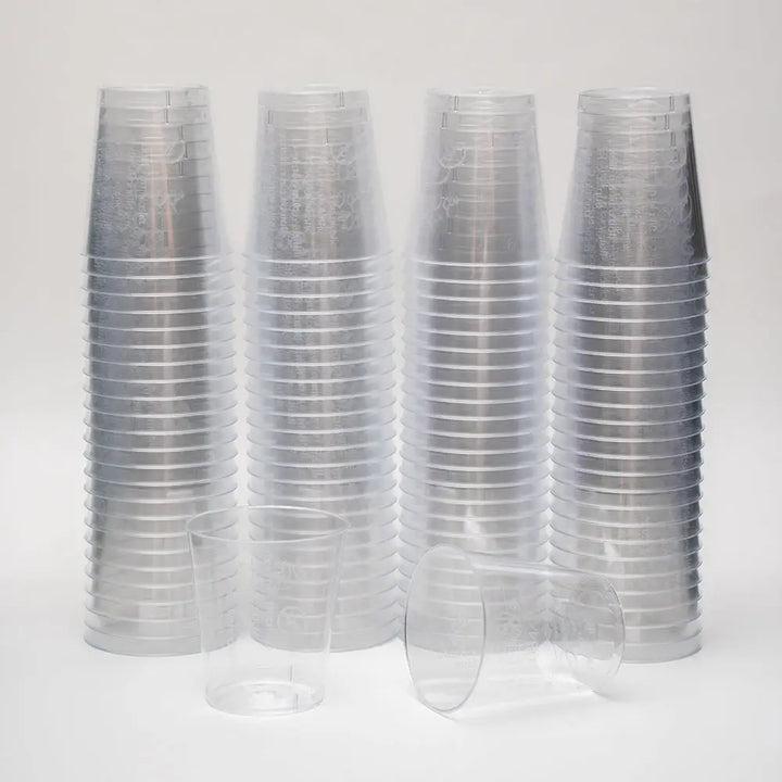 Stacks of clear 2cl plastic shot glasses with lining for precise measuring