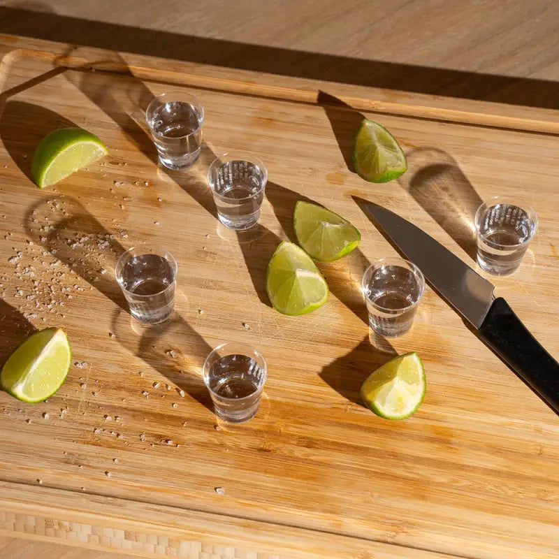 Plastic shot glasses with tequila shots and lime wedges for party servings