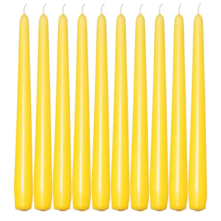 Ten slender yellow taper candles in a row for elegant dinner settings