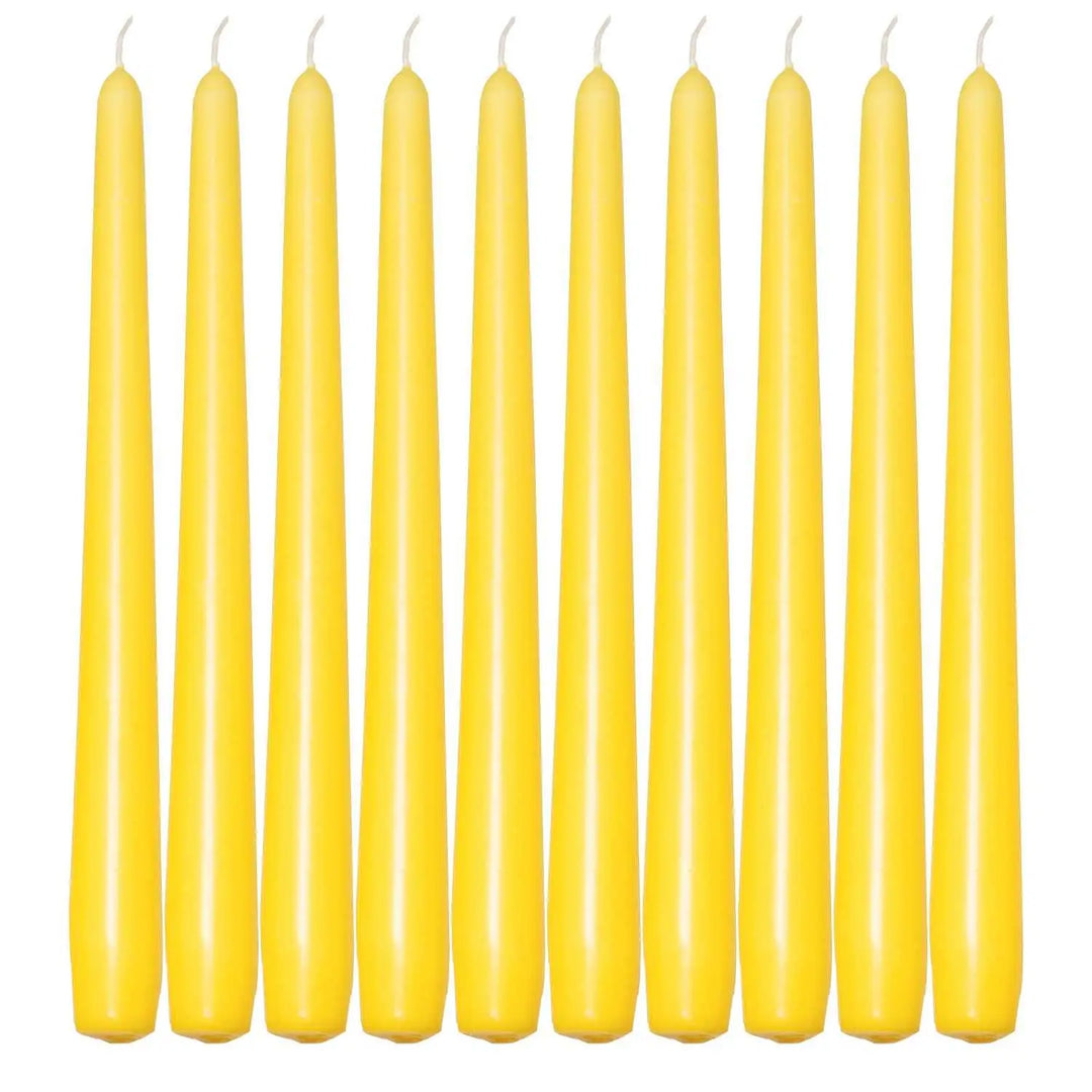 Ten slender yellow taper candles in a row for elegant dinner settings