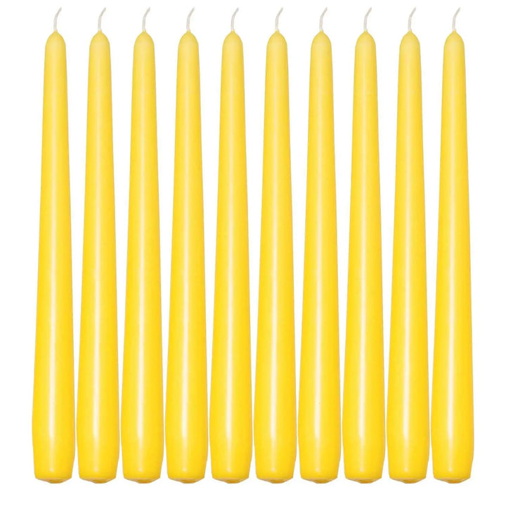 Ten slender yellow taper candles in a row for elegant dinner settings