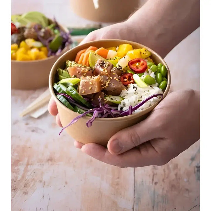Fresh poke bowl with tuna, rice, vegetables in round kraft food container with lid