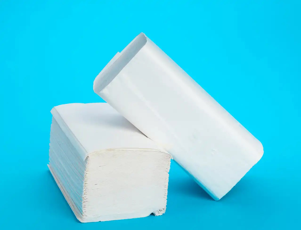 White paper towel rolls stacked together.