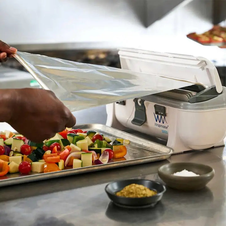 Food slicer being used to slice vegetables with Wrapmaster 3000 Dispenser - 63M98