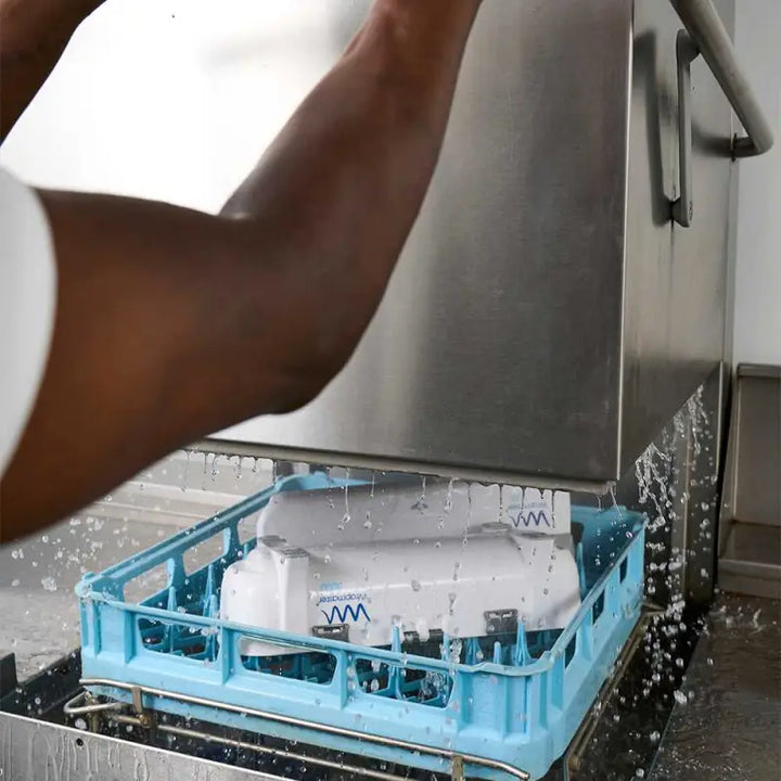 Dishwasher rack filled with dishes being sprayed with water, featuring Wrapmaster 3000 Dispenser 63M98