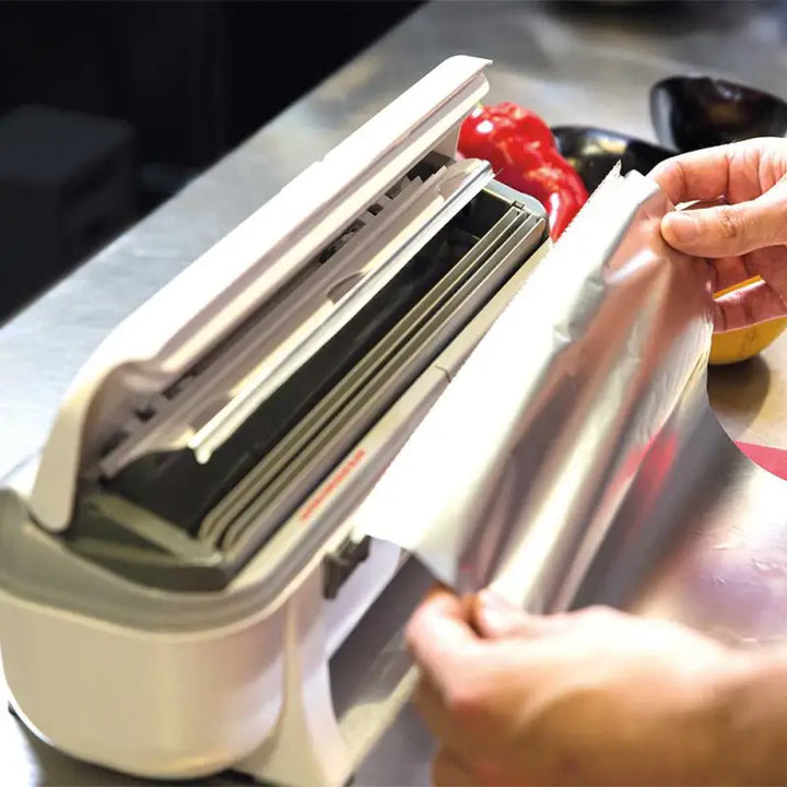 Hands operating a food vacuum sealer with Wrapmaster 3000 Dispenser - 63M98 Takes Film