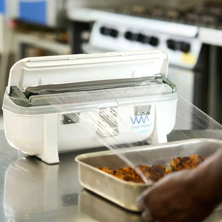 Food vacuum sealer machine with open lid next to Wrapmaster 3000 Dispenser - 63M98 Takes Film
