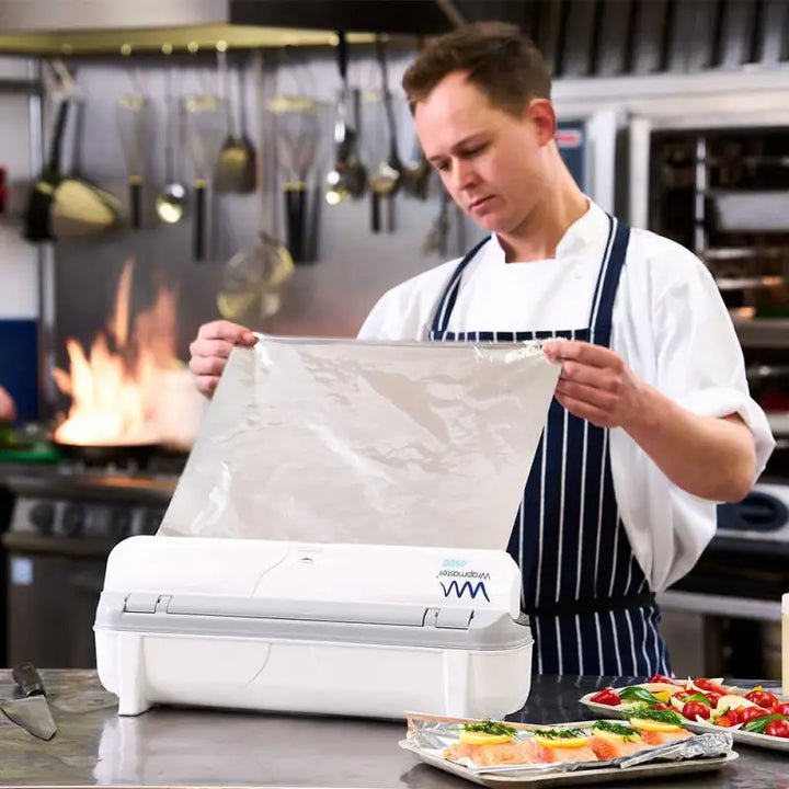 Chef in a white coat using kitchen appliance with Wrapmaster 4500 Aluminium Foil 24C55