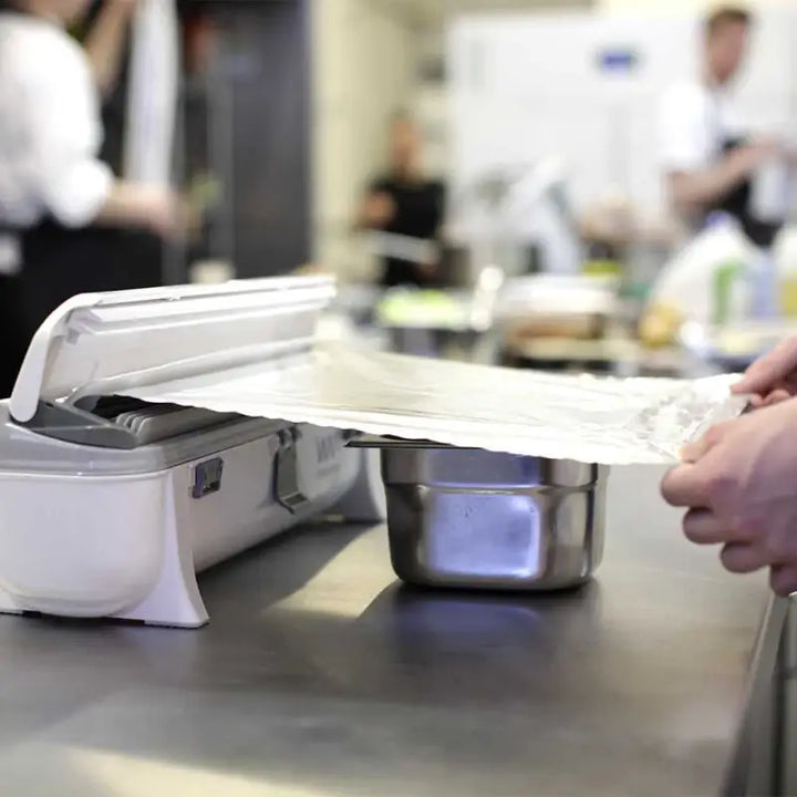 Food packaging machine sealing a tray with plastic film using Aluminium Foil 24C55